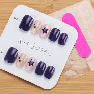 Detail of dark purple cat-eye press-on nails with blue stars and pink glitter accents