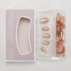 Close-up of nude pink cat-eye press-on nails with gold French tips and rhinestones