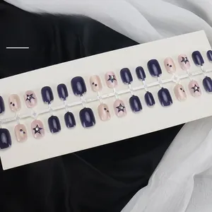 Detail of deep purple glitter press-on nails with blue stars and rhinestone accents
