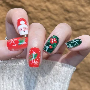 Faux ongles de Noël avec motifs Père Noël et flocons de neige en rouge et vert festif