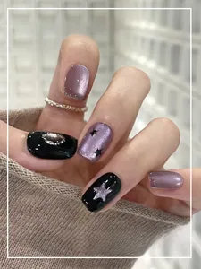 Detailed close-up of purple and black cat-eye nails with silver stars and fine glitter