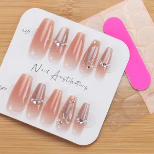 Macro view of ballerina nude pink gradient press-on nails with pearls and rhinestones