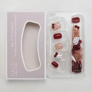Short wine red bow press-on nails with white dots and cat eye effect in packaging