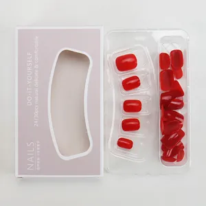 Glossy cherry red press-on nail kit with 24-30 pieces and packaging on grey background