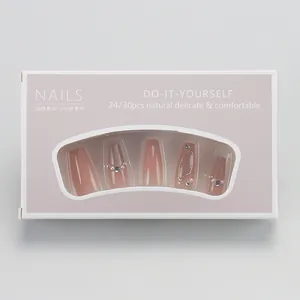 Detail of pink gradient press-on nails with pearls, crystals, and gold wavy lines