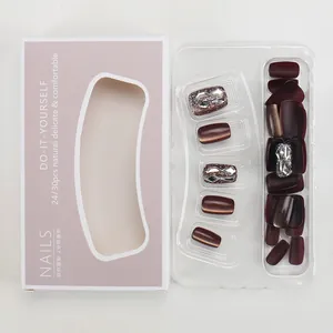 Detail of short burgundy press-on nails with glitter accents and luxury rhinestone decor