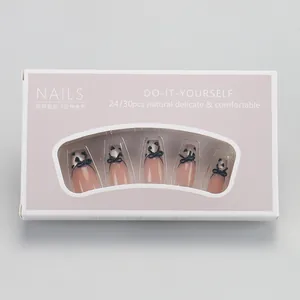 Detail of coffin-shaped pink and black bow heart press-on nails in clear window box