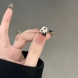 Handmade ballerina nails in nude pink with black bows and heart patterns on tips