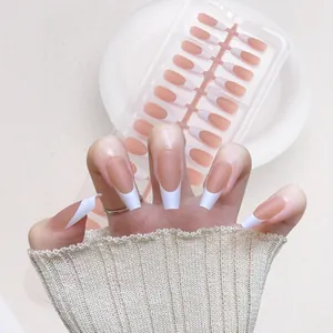 Classic French coffin fake nails with nude pink base and white tips on display rack