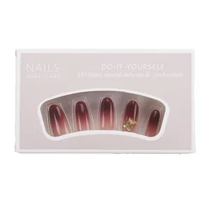 Faux ongles élégants dégradés rouge-brun avec décoration de strass dorés de luxe en boîte