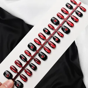 Detailopname van 30 handgemaakte kunstnagels met stermotieven en rode edelsteenaccenten