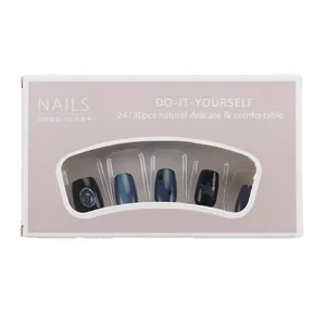 Korte blauwe cat-eye kunstnagels met sterversieringen in vensterverpakking