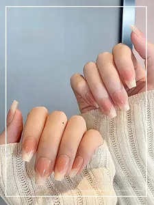Detailed view of French V-shape press-on nails in elegant nude pink and cream tones