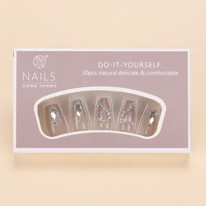 Detail of nude pink cat-eye press-on nails with glitter gradient and rhinestone accents