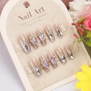Detailed view of handmade nude cat-eye press-on nails with silver glitter and rhinestones