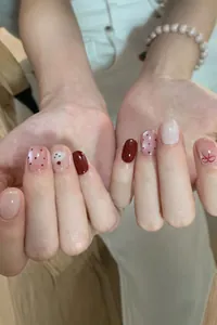 Detailed close-up of cat-eye press-on nails with cute cherry and bow-tie hand-painted designs