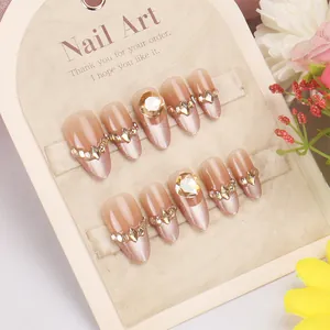 Handmade press-on nails with nude pink cat eye gradient and sparkling rhinestones