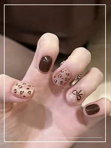 Detalle de uñas postizas ojo de gato de leopardo con lazos y acabado en marrón