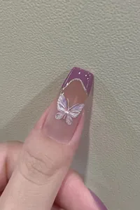 Detail of square purple french nails with 3D iridescent butterfly and pearl accents