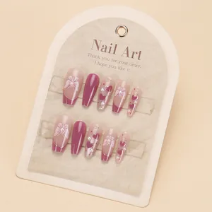 Detail of pink and purple cat eye press-on nails with 3D bows and heart pearls