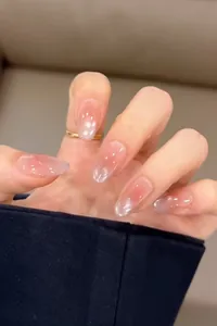 Detail of long oval press-on nails with translucent pink cat-eye and pearl finish