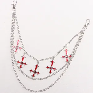 Detailed macro view of triple-layered silver hip chain with red enamel cross charms