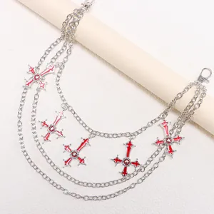 Multilayer hip-hop silver metal waist chain with red oil-drop cross pendants on white prop