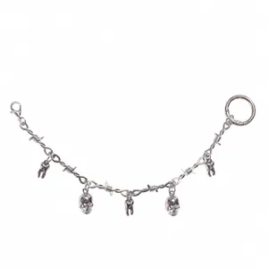 Macro detail of gothic skull shoe chain with barbed wire links and alloy pendants