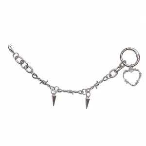 Detailed macro view of silver punk shoe chain with heart charm and metallic spikes
