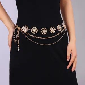 Goldene geometrische Taillenkette mit Perlen und Straßsteinen auf schwarzem Kleid