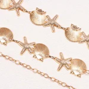 Bohemian gold metal waist chain with starfish, seashells, and faux pearls in macro view
