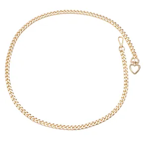 Minimalist gold metal waist chain with heart pendant and Cuban link design on white background