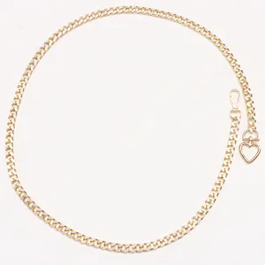 Detail of gold metal chain waist belt with polished heart buckle and lobster clasp
