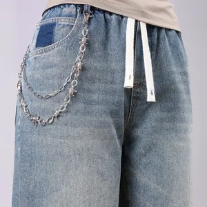 Detail of double-layer hip-hop punk waist chain with thorn metal design on blue jeans