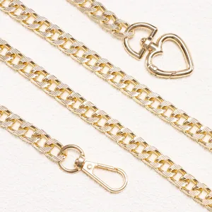 Gold metal chain belt with heart-shaped buckle and textured links on white background
