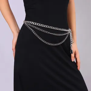 Détail de la chaîne de taille multicouche en métal argenté avec pendentifs sur robe noire