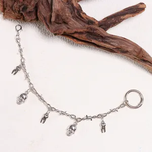 Silver punk shoe chain with skull and tooth charms featuring a barbed wire style link
