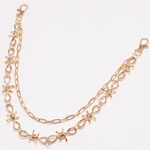 Detail of golden double-layer punk waist chain with barbed wire design and lobster clasps