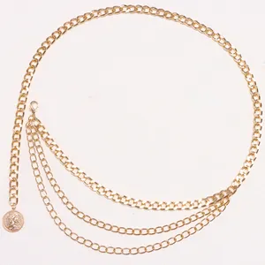 Détail de la ceinture à chaînes dorées multicouches avec un pendentif pièce élégant