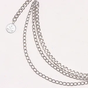Détail de la chaîne multicouche en alliage argenté avec un pendentif pièce vintage gravé