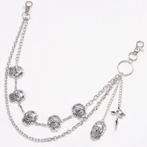 Close-up of multilayered silver metal pant chain with skull charms and cross pendant