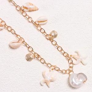Gold ocean themed charm chain featuring natural starfish and seashell pendants on white surface
