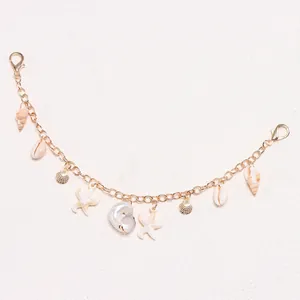 Detail of golden metal chain with sea shells, starfish and conch charms for DIY accessory