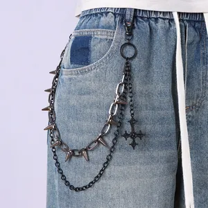 Cadena de cintura punk multicapa con púas de metal y cruz sobre vaqueros azules
