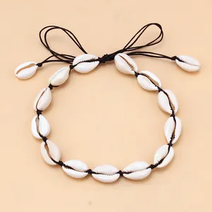 Detail of white cowrie shells necklace with adjustable black woven cord for women