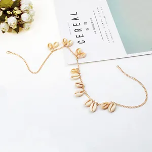 Detailopname van gouden schelpenketting met natuurlijke schelpen op witte achtergrond