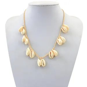 Detailweergave van een gouden boho-ketting met meerdere natuurlijke kauri-schelpen