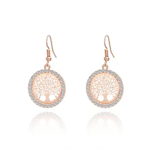 Close-up of rose gold tree of life drop earrings with sparkling crystal accents