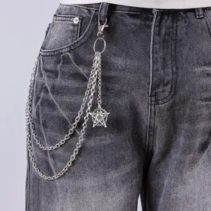 Detail of silver multilayer punk chain with pentagram star pendant on denim jeans