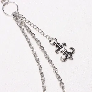 Detail of multi-layered silver waist chain featuring a vintage fleur-de-lis pendant